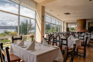 a restaurant with white tables and chairs and large windows at Hotel Jose Antonio Puno in Puno +30 photos