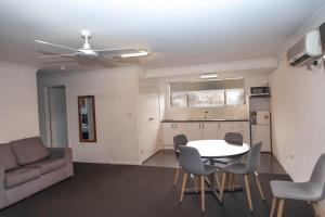 ein Wohnzimmer mit einem Tisch, Stühlen und einem Sofa in der Unterkunft Matilda Motor Inn in Dubbo