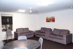 uma sala de estar com dois sofás e uma mesa em Matilda Motor Inn em Dubbo
