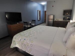 ein Schlafzimmer mit einem großen Bett und einem Flachbild-TV in der Unterkunft HomeTowne Studios by Red Roof Prattville in Prattville