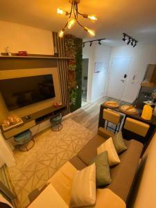 a living room with a couch and a large television at Apartamento Novo Moderno-8Km Aeroporto GRU in Guarulhos