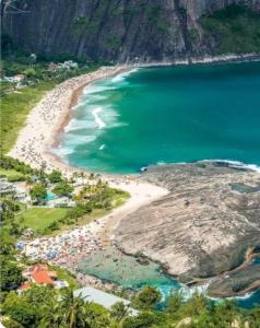 eine Luftansicht auf einen Strand mit einer Gruppe von Personen in der Unterkunft Apart. em Icaraí na quadra praia com garagem Wi-fi in Niterói