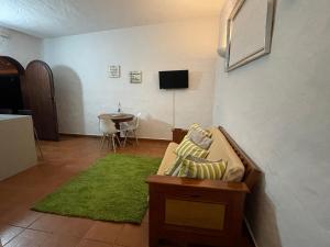 a living room with a couch and a green rug at Bed&Ride La Manigua in Ojos de Garza