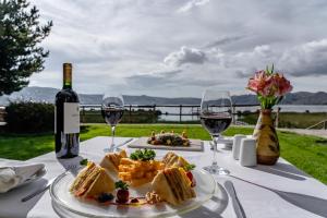 una mesa con un plato de comida y copas de vino en Hotel Jose Antonio Puno, en Puno