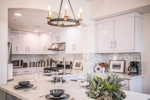 a kitchen with white cabinets and a table with wine glasses at Long Beach Mordern APT in Long Beach