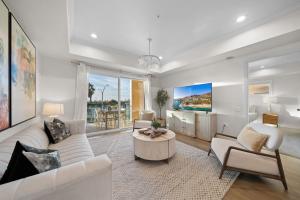 a living room with white furniture and a tv at Long Beach Mordern APT in Long Beach