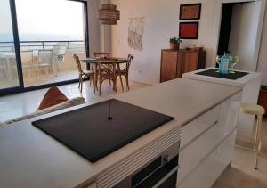 a kitchen with a counter with a table and a dining room at Top-Floor Beachfront Apartment with Parking, Pool, & Spacious Sea-View Balcony in Villajoyosa
