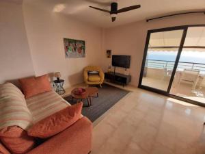 a living room with a couch and a view of the ocean at Top-Floor Beachfront Apartment with Parking, Pool, & Beautiful Sea-View Balcony in Villajoyosa
