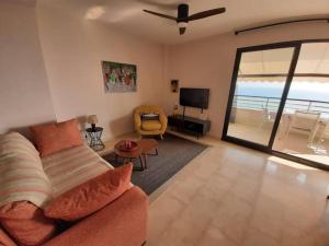 a living room with a couch and a view of the ocean at Top-Floor Beachfront Apartment with Parking, Pool, & Spacious Sea-View Balcony in Villajoyosa