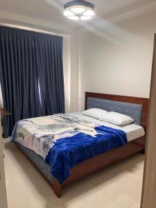 1 dormitorio con 1 cama con manta azul y ventana en Robert's Place, Alphabet City A003, en Sakumona