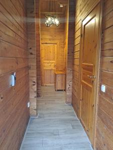 a hallway in a cabin with wooden walls and a door at Juromi 42 in Gramsbergen