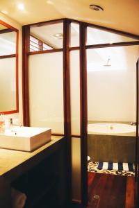 een badkamer met een bad, een wastafel en een spiegel bij Amazing SUITE in Casco Antiguo in Panama-Stad