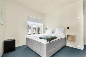 a white bedroom with a large bed with a window at Central Guest House - Bedroom with en suite Bathroom in Stavanger