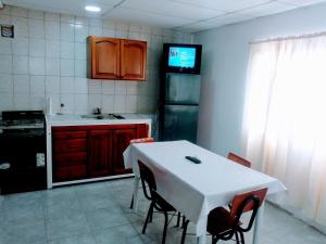 eine Küche mit einem Tisch und einem weißen Tisch und Stühlen in der Unterkunft Marcelo in Carmen de Patagones