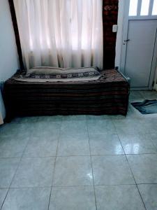 ein Bett auf einem gefliesten Boden in einem Zimmer in der Unterkunft Marcelo in Carmen de Patagones