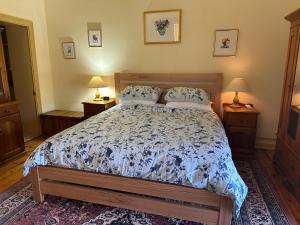 a bedroom with a bed with a blue and white comforter at Robe House Heritage Accommodation in Robe