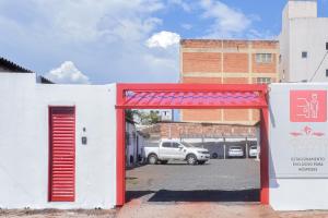 eine rote Tür zum Parkplatz mit LKW in der Unterkunft Honorato Hotel in Rio Verde