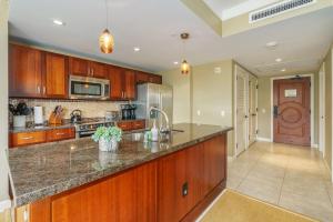 Honua Kai Hokulani 934, Large Lanai, No Carpet, AC في لاهينا: مطبخ بدولاب خشبي وقمة من الجرانيت
