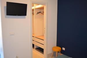 um quarto com um armário com uma televisão e uma cadeira em Open Space Centralissimo Nettuno fronte Porto em Nettuno
