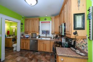 uma cozinha com armários de madeira e paredes verdes em Berrodin Bed & Breakfast em Akron