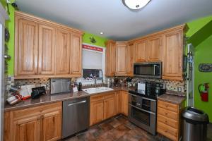 uma cozinha com armários de madeira e electrodomésticos pretos em Berrodin Bed & Breakfast em Akron