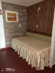 Cama en habitación con pared de madera en Casa Playa Sur en Federación