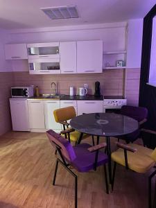 een keuken met een tafel en stoelen en een keuken met witte kasten bij Apartman Monti Vlašić in Vlasic