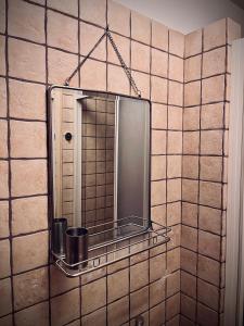 een badkamer met een spiegel op een betegelde muur bij Studio73 Ljubljana in Ljubljana