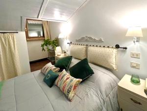 una camera da letto con un letto con cuscini verdi di Casa Porta Fontevecchia panoramica a Spello