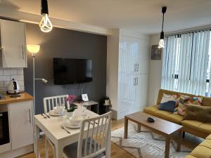 a kitchen and living room with a table and a couch at Stoke Newington Deluxe Flat in London