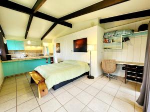 a bedroom with a large bed and a kitchen at Arnott's Lodge & Hiking Adventures in Hilo