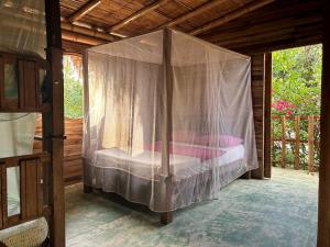 Cama en habitación con mosquitera en Hostal Corazón de Tagua, en Palomino
