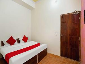 a bedroom with a bed and a wooden door at The Golden Crown in Faridabad