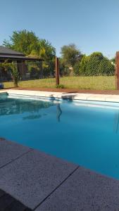una piscina con acqua blu in un cortile di La Mora Home - Casa de Campo a Victoria