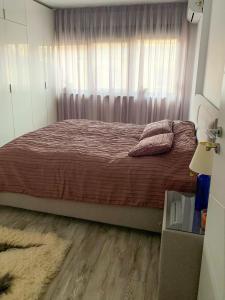 a bedroom with a large bed with a window at Central apartment - Cismigiu & Izvor Park in Bucharest