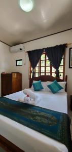 a bedroom with a large white bed with blue pillows at Private 1-BR Bungalow in Moalboal in Moalboal