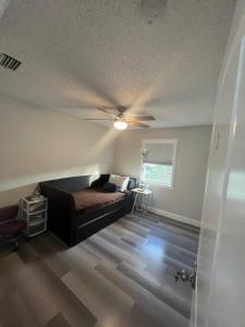 a living room with a couch and a ceiling fan at House close Baldwin-park Lake & Downtown Orlando in Orlando