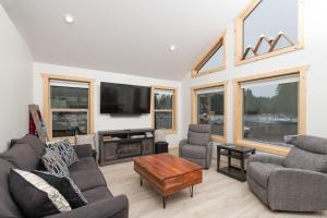 a living room with couches and a flat screen tv at The Alpine Cabin in Valemount