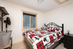 a bedroom with a bed and a window at The Alpine Cabin in Valemount
