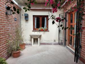 a courtyard with a window and a bench and flowers at Hospedajes JUJUY in Palpalá