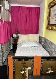a bed in a room with a pink wall at moon lotus abode(月蓮居) in New York