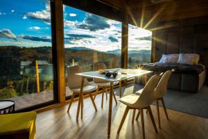 a bedroom with a table and chairs in front of a window at Czas i Las Glamping in Sadek