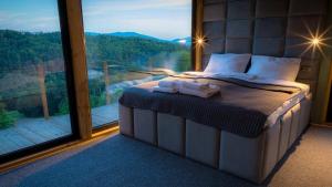 een bed in een kamer met een groot raam bij Czas i Las Glamping 