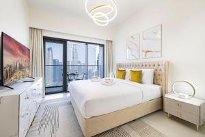 a white bedroom with a large bed and a large window at SmartStay at Burj Royale - Full Burj Khalifa View - Brand New Luxury Apartments in Dubai