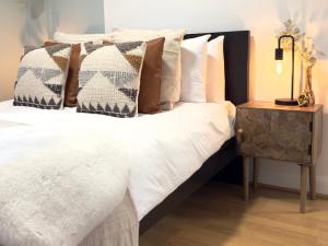 a bedroom with a bed with pillows and a table at City Centre Apartment Near the University and Bodleian Library in Oxford