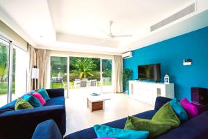 a blue living room with a blue couch and a tv at Special offer! Villa Bueno with private pool&beach in Punta Cana