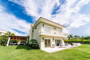 une villa avec une pelouse en face de celle-ci dans l'établissement Special offer! Villa Bueno with private pool&beach, à Punta Cana