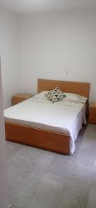 a bed with a wooden headboard in a room at Apartments A&A - Santa Maria in Santa Maria