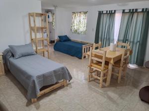 ein Wohnzimmer mit einem Bett, einem Tisch und Stühlen in der Unterkunft Complejo Lucero in Santa Rosa