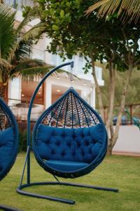 a blue swing sitting on the grass in a yard at Casa Cancun Eventos e Hotel Boutique in Penha